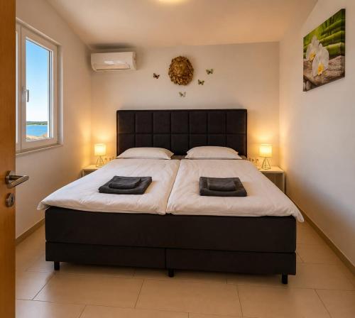 a bedroom with a large bed with two lamps at Graf-Apartments-Vir-Zadar in Vir