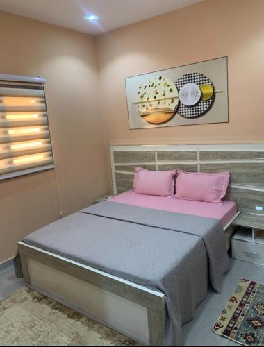 a bedroom with a bed with pink pillows at Immeuble Racine in Ngaparou