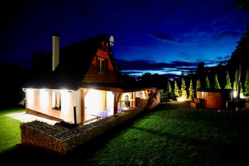 a small house at night with lights on it at Chata na Zbojskej - Zbojská in Pohronská Polhora