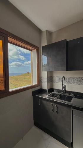 a kitchen with a sink and a window at zahara appartement in Tangier