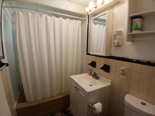 a bathroom with a white shower curtain and a sink at 16 sycamore rd in Bayonne
