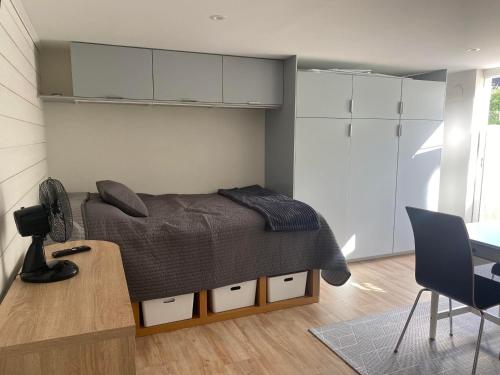 a bedroom with a bed and a table and a desk at Centralt Semesterboende in Halmstad