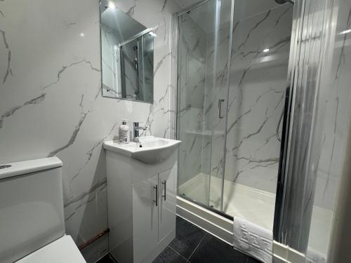 a white bathroom with a shower and a sink at Charlie Hotel in London