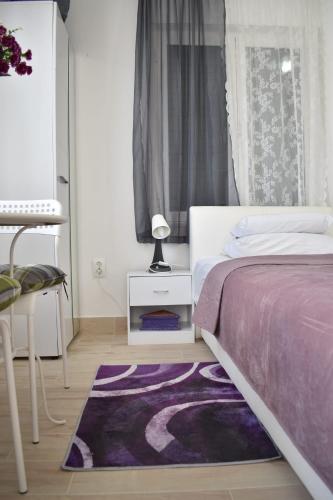 a bedroom with a bed and a purple rug at Kuća za odmor Nada in Marina