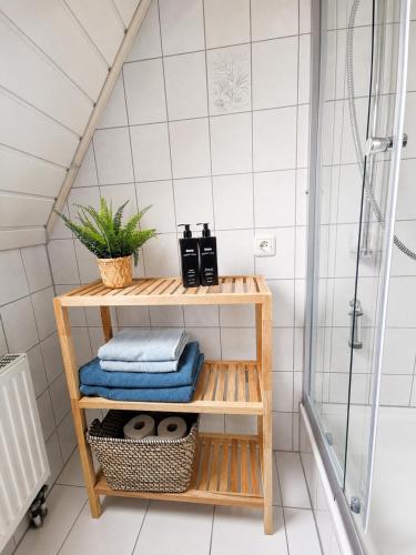 a bathroom with a bamboo shelf with towels at Wohnung mit hist. Altstadt Charme in Nördlingen