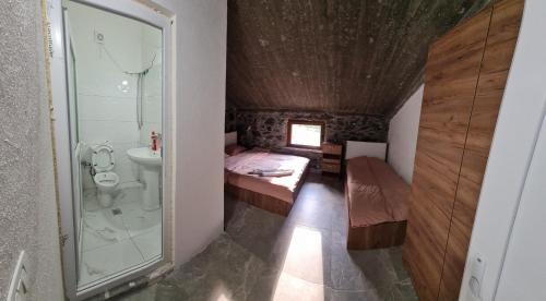 a small bathroom with a bed and a shower at Sylbica Guesthouse in Tropojë