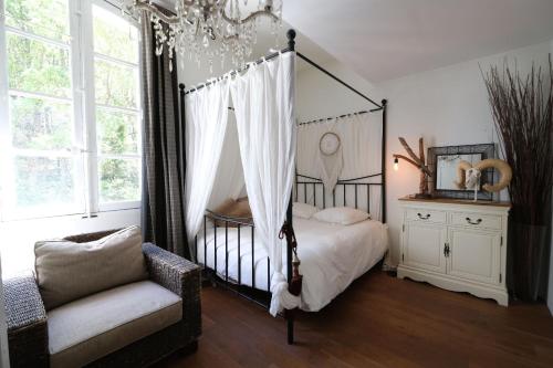 a bedroom with a canopy bed and a chair at LS7-468 - Eicela in Saint-Antonin-sur-Bayons