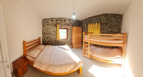 a bedroom with two bunk beds and a window at Sylbica Guesthouse in Tropojë