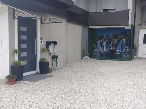 a front door of a building with a painting on the wall at Green Home Bihać in Bihać