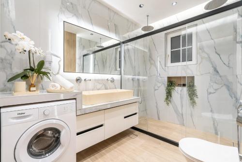 a white bathroom with a washer and dryer in it at Eldorado Luxury Villa in Afantou