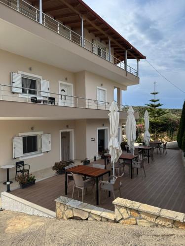 a house with a deck with tables and umbrellas at Vila Ervin Double Room in Ksamil