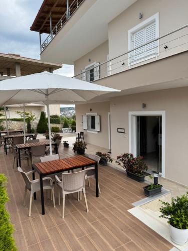 a patio with tables and chairs and an umbrella at Vila Ervin Double Room in Ksamil
