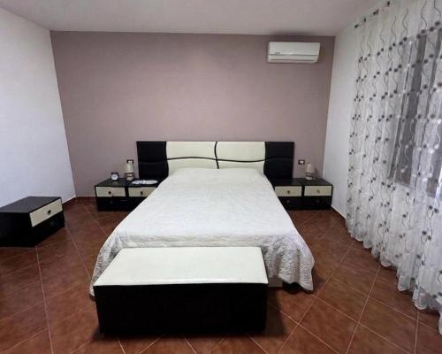 a bedroom with a large bed with white sheets at Colombo' s House in Shkodër