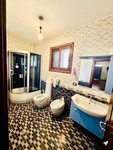 a bathroom with two sinks and a tub and two toilets at Colombo' s House in Shkodër