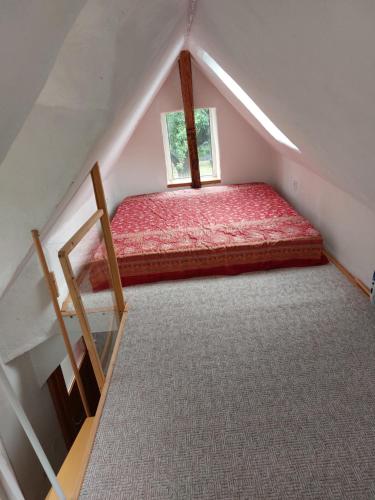 a attic room with a bed and a window at Haus im Garten in Grebenau