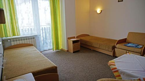 a hotel room with two beds and a window at Wiktorowa Chata in Wierchomla Wielka