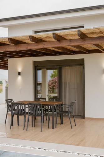 a dining room with a wooden table and chairs at Nerina House in Paralia Katerinis