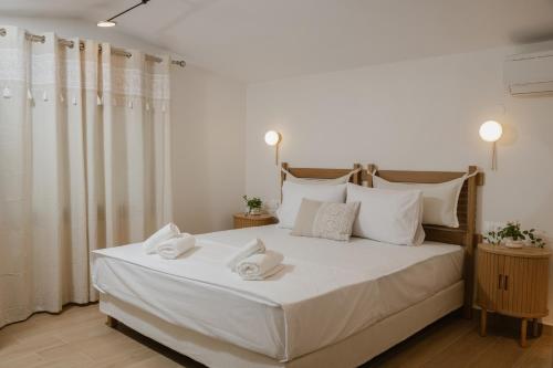 a bedroom with a white bed with towels on it at Nerina House in Paralia Katerinis