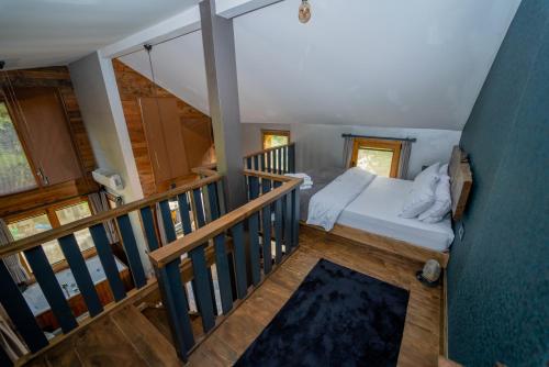 a small bedroom with a bed and a staircase at Saffire Doğa Evleri in Güneyköy