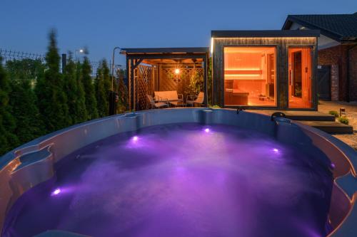 a hot tub in the backyard of a house at night at Domki DOMINO w Darłówku nad morzem in Darłowo