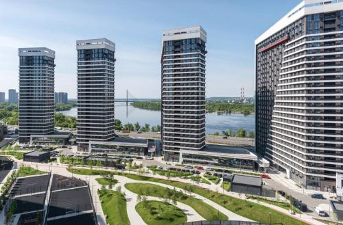 a view of three tall buildings and a river at Great Apart - Вид на Дніпро - 6 поверх - укриття на території ЖК in Kyiv