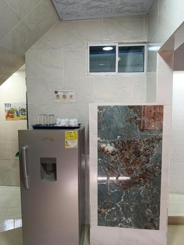 a kitchen with a stainless steel refrigerator and a window at APARTAMENTOS LIZ MARIA in Coveñas