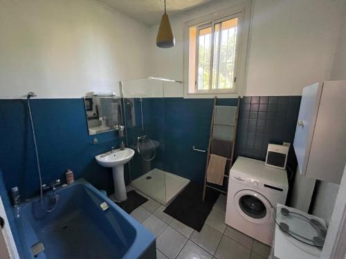 a bathroom with a sink and a washing machine at Grande maison familiale proche mer in Elne