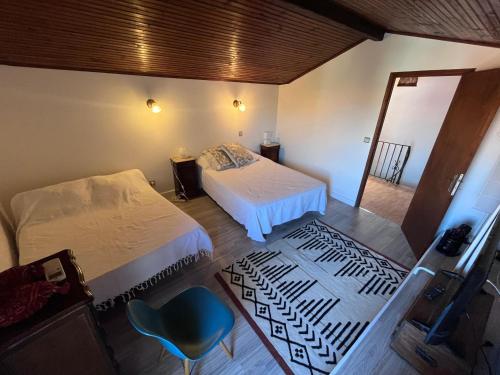a bedroom with two beds and a blue chair at Grande maison familiale proche mer in Elne