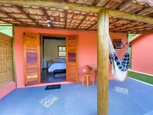a room with a bed and a hammock in a house at POUSADA ESTÂNCIA DAS CACHOEIRAS in Cunha
