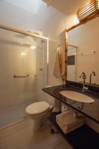 a bathroom with a toilet and a sink and a shower at Casa Viva Itamambuca in Ubatuba