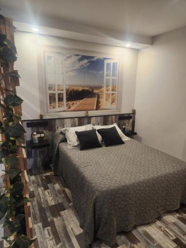 a bedroom with a bed and a painting on the wall at Apartamento Sol in Suances