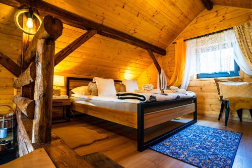 a bedroom with a bed in a log cabin at Ranczo Lanckorona in Kalwaria Zebrzydowska