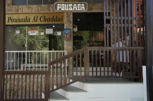 a building with a staircase in front of a store at Pousada Al Chaddai in São Lourenço