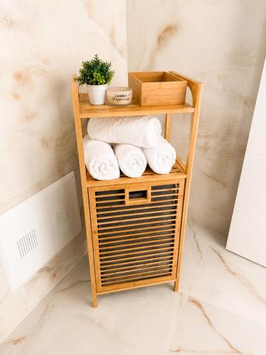 a bamboo shelf with towels on it in a bathroom at Meis Villas in Dhërmi