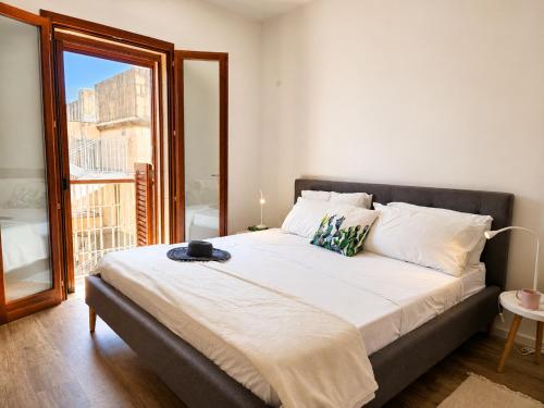 a bedroom with a large bed with a large window at Harba - An Escape at Fort Chambray in Għajnsielem