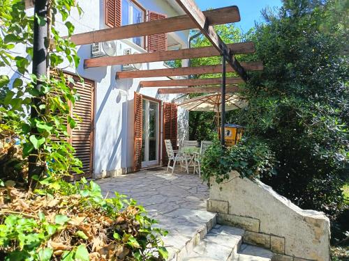 a patio of a house with a wooden pergola at Pine Breeze in Punat