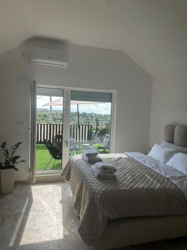 a bedroom with a bed and a sliding glass door at Mia Bella in Sremska Kamenica