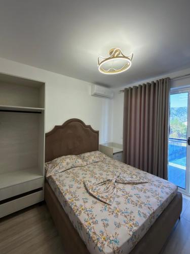 a bedroom with a bed with a large window at Hotel De La Playa in Velipojë