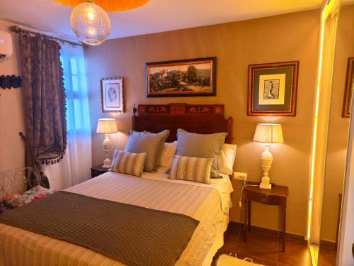 a bedroom with a large bed with two lamps at La Terraza del Castillo- Playa de Rota in Rota