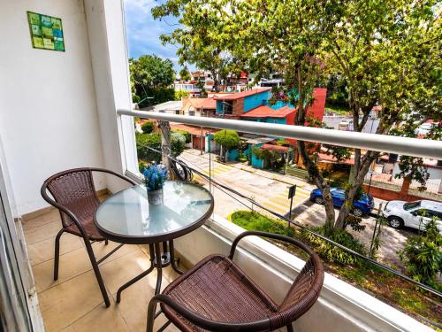 a table and chairs on a balcony with a view of a city at Loft Sipeh Xalapa Departamento 4 in Xalapa