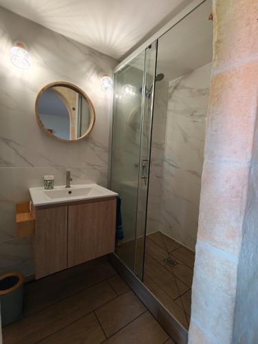 a bathroom with a sink and a shower with a mirror at Ti Colibri in Deshaies