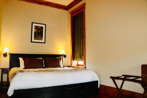 a bedroom with a bed and a window at The Kleemann House-1883 Historic Downtown Hotel in Custer