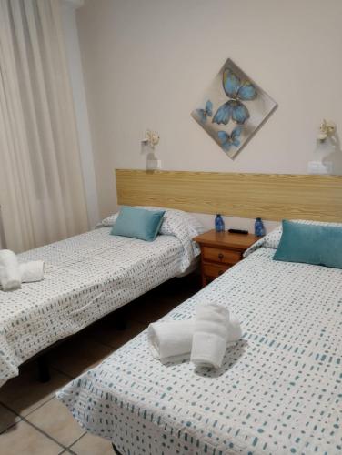 two beds with towels on them in a bedroom at Hostal Posada Royuela in Royuela