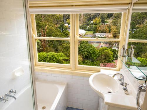 a bathroom with a sink and a tub and a window at Charnwood Cottages in Warburton