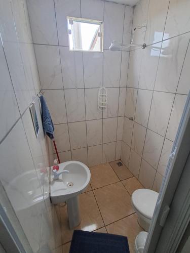 a small bathroom with a toilet and a sink at Suite Nomar 1 in Brotas