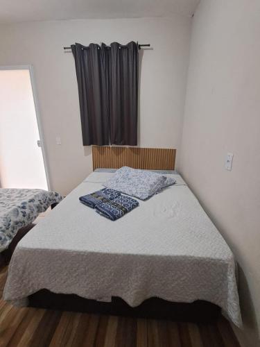 a small bedroom with a bed with a window at Suite Nomar 1 in Brotas