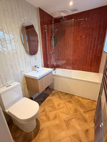 a bathroom with a toilet and a sink and a tub at St Johns Central Canterbury Cottage in Canterbury