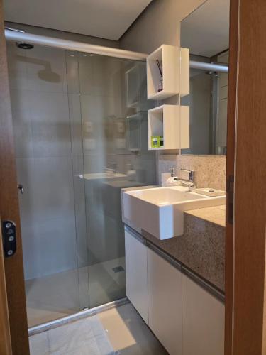 a bathroom with a sink and a mirror at Apartamento Jade Hotel - Park Sul in Brasília