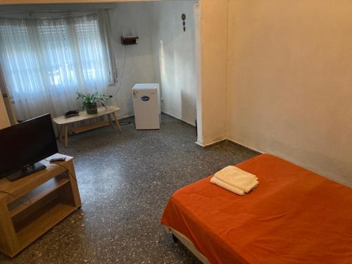 a room with a bed and a small refrigerator at Habitacion Privada, Single Room in Paysandú