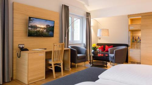 a hotel room with a bed and a desk at Romantik Hotel Rindenmühle in Villingen-Schwenningen